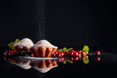 Siyah yansıtıcı sırtına şeker tozu serpiştirilmiş çörekler.