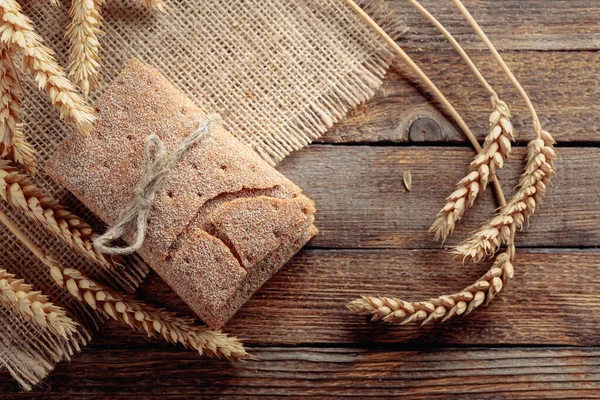 Rye crackers and ears on a old wooden table. — Stock Photo, Image