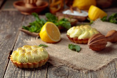 Eski ahşap bir masada limon kremalı ve nane şekerli tart. 