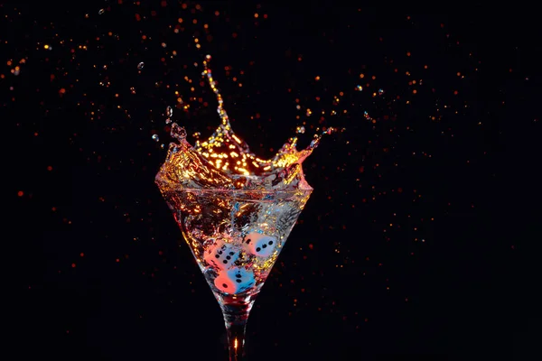 Dice fall in a glass of martini. Colourful cocktail in glass wit — Stock Photo, Image