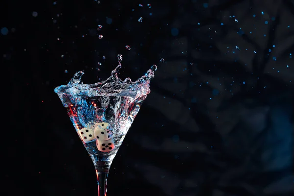 I dadi cadono in un bicchiere di martini. Cocktail colorato in vetro arguzia — Foto Stock