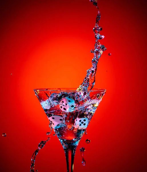 Los dados caen en un vaso de martini. Cóctel colorido en el ingenio de cristal — Foto de Stock