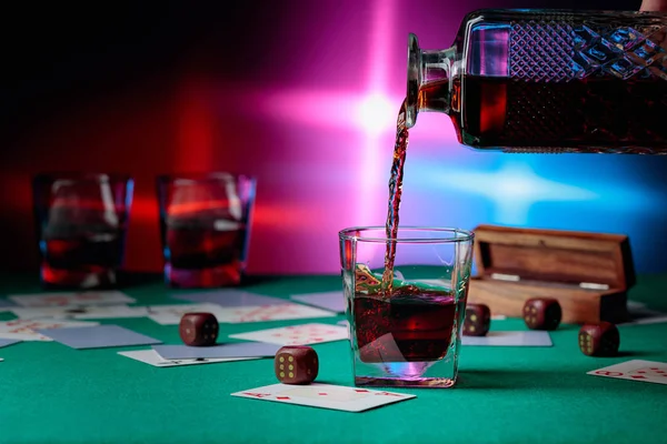 Kaszinó asztal kártyákkal és kockákkal. A whiskyt egy pohárba öntik. — Stock Fotó