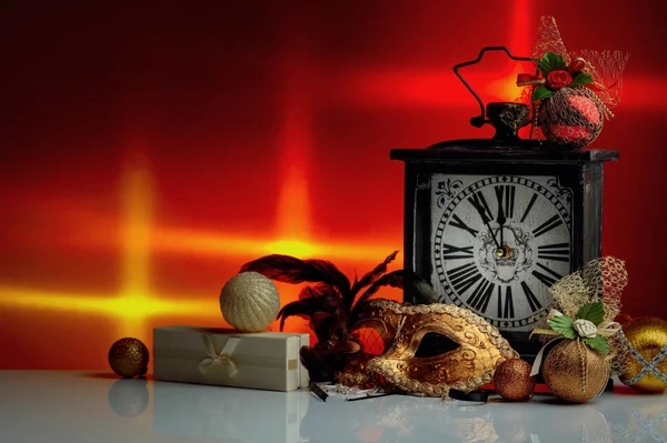 Vintage clock with Christmas decorations, gift and carnival mask — Stock Photo, Image