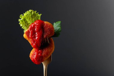 Ketçaplı kızarmış tavuk nugget, maydanoz ve çatallı salata..