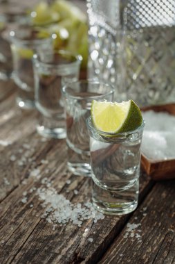 Eski ahşap arka planda tuz ve kireç ile tekila.