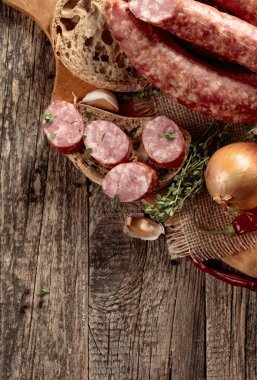 Eski ahşap bir masada ekmek ve baharat ile kuru-tedavi sosis.
