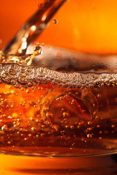 Whisky is poured into a glass with ice. — Stock Photo, Image