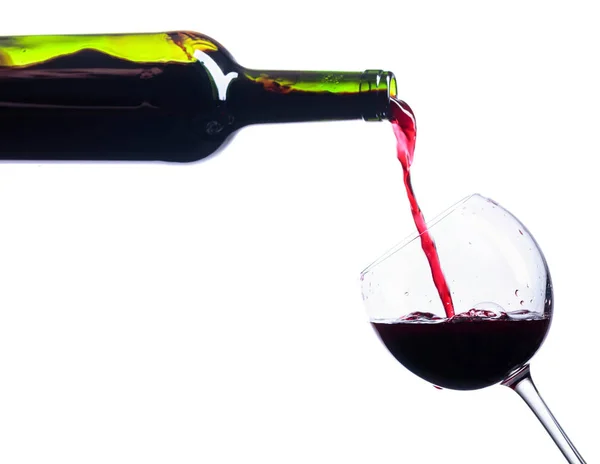 Pouring red wine from bottle to glass isolated on white. — Stock Photo, Image