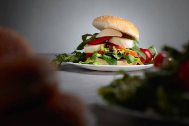 Mozzarella peyniri, domates, salata mutfak masasında ile sandviç.