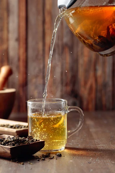 Čerstvý zelený čaj se nalévá z konvice do hrnku. — Stock fotografie
