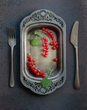 Redcurrants metal çanak çatal ve bıçak üzerinde. 