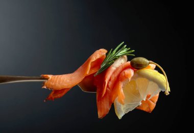 Alabalık filetosu, limon dilim, Kapari ve biberiye.