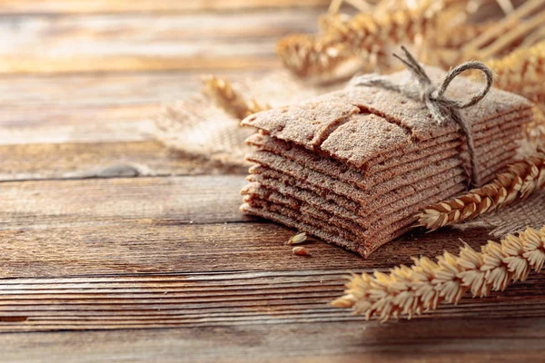 Roggen-Cracker und Ähren auf einem alten Holztisch. — Stockfoto