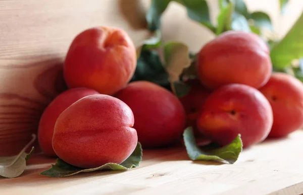 Apricots with leaves on a wooden table. — Stock Photo, Image