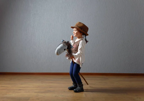 Mignonne petite fille habillé comme un cow-boy jouer avec un fait maison h — Photo