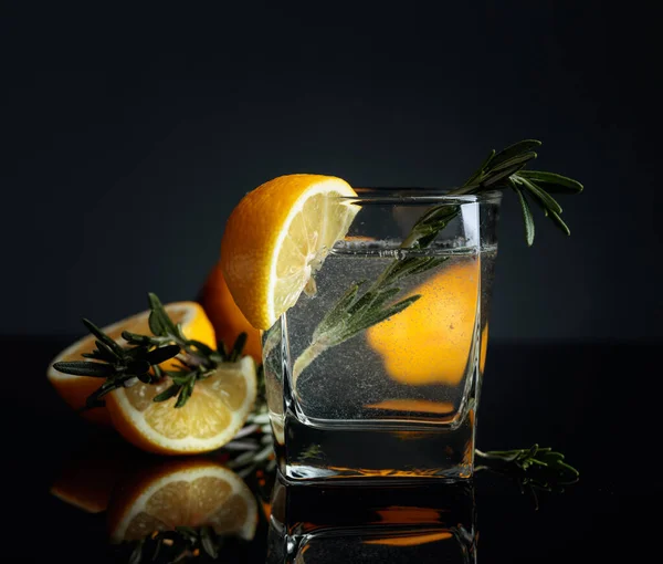 Cocktail Gin Tonic mit Zitronenscheiben und Rosmarinzweigen. — Stockfoto