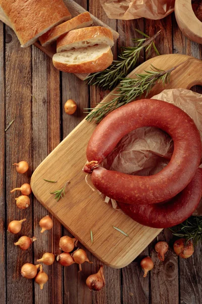 Räucherwurst mit Brot und Gewürzen auf einem alten Holztisch. — Stockfoto