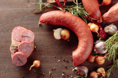 Eski ahşap bir masada salamlı sandviç..