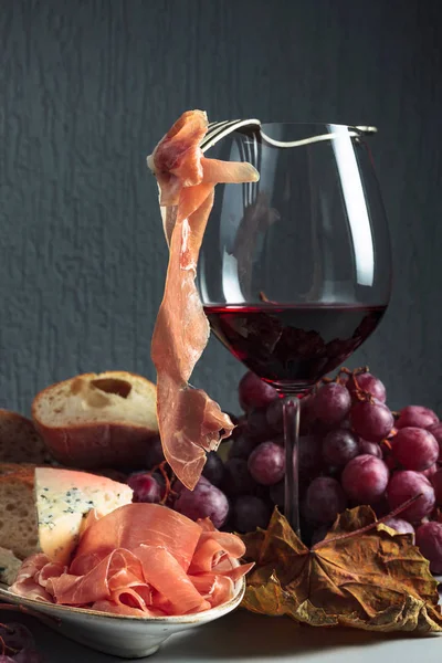 Asztali pohár vörösbor, szőlő, kenyér, kék sajt és pro — Stock Fotó