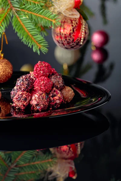 Truffes au chocolat sur une assiette noire et sapin de Noël . — Photo