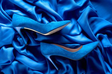Bir ipek arka plan üzerinde Mavi kadın kadife ayakkabı.