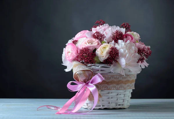 Bouquet de pivoines roses dans un panier blanc avec ruban rose . — Photo