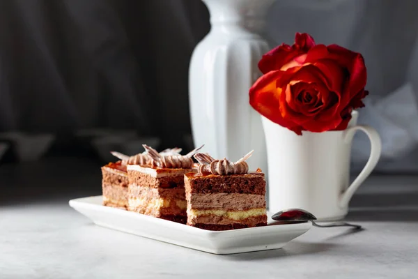 Pasteles en capas con rosa en una mesa de marmorea blanca . — Foto de Stock