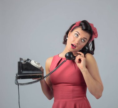 Mercan elbiseli çekici kız telefonda duygusal olarak konuşuyor.