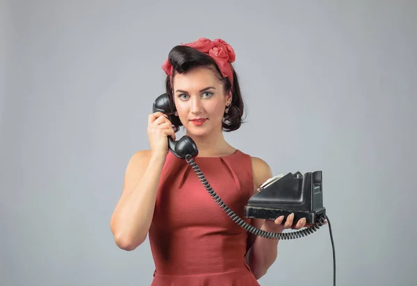 Menina atraente em um vestido de coral emocionalmente falando sobre o phon — Fotografia de Stock