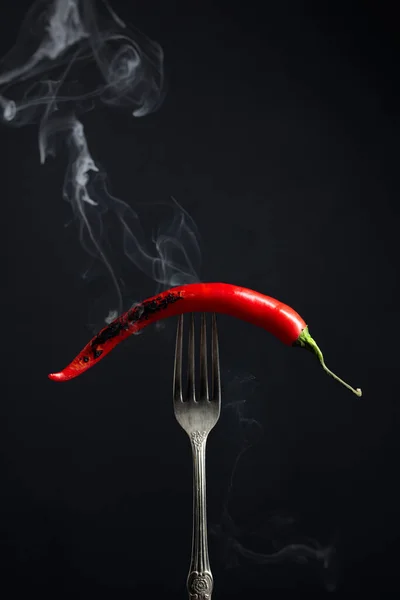 Pimienta roja picante fumando en un tenedor. Concepto de especias . — Foto de Stock