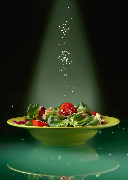 Zelený salát s třešňovýma rajčaty, vlašskými ořechy a sezamem. — Stock fotografie
