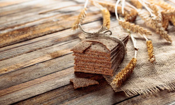 Rogge crackers en oren op een oude houten tafel. — Stockfoto