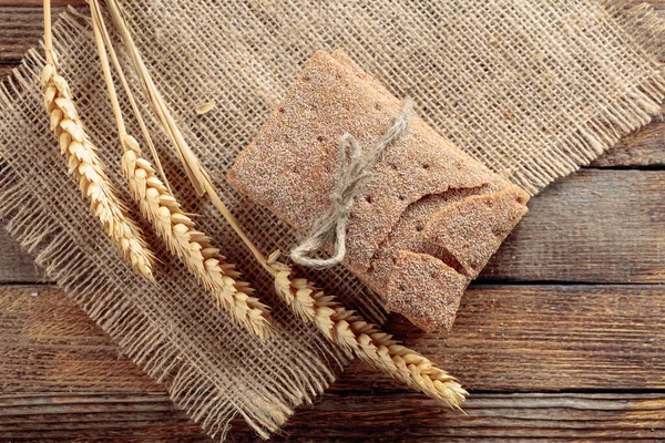 Galletas de centeno y orejas en una vieja mesa de madera . — Foto de Stock