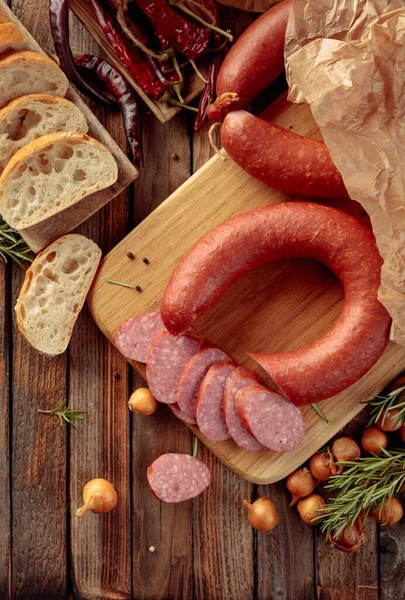 Salsiccia affumicata con pane e spezie su un vecchio tavolo di legno . — Foto Stock