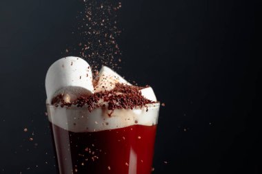 Çikolata parçacıkları serpiştirilmiş kremalı sıcak çikolata..