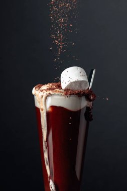 Çikolata parçacıkları serpiştirilmiş kremalı sıcak çikolata..