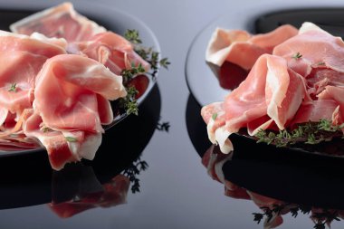 Siyah tabakta kekik olan Prosciutto..