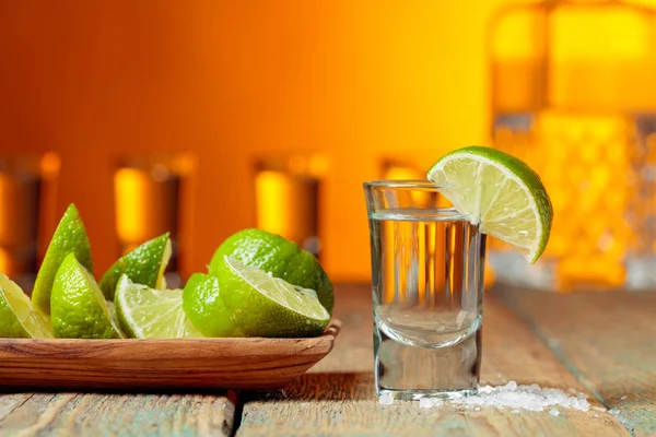 Tequila med salt och lime på en gammal träbakgrund. — Stockfoto