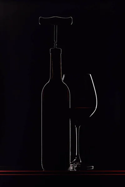 Bouteille avec tire-bouchon et verre de vin rouge . — Photo