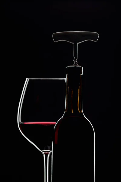 Lahvička s vývrtkou a sklenicí červeného vína. — Stock fotografie