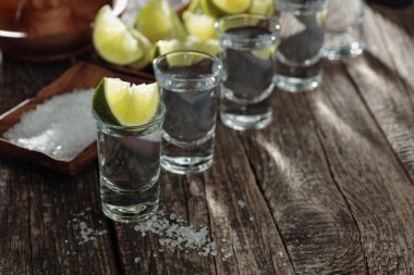 Eski ahşap arka planda tuz ve kireç ile tekila.