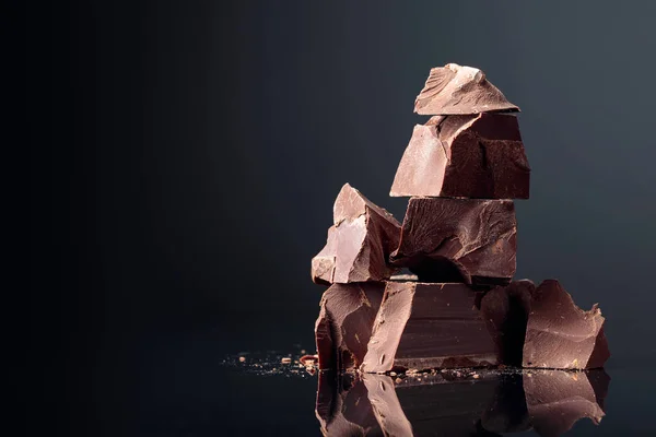 Кусочки тёмного шоколада на тёмном фоне . — стоковое фото