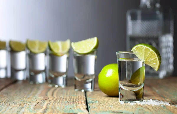 Tequila med salt och lime på en gammal träbakgrund. — Stockfoto