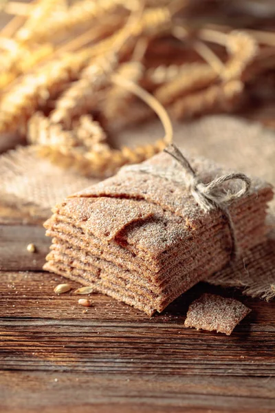 Rye crackers and ears on a old wooden table. — Stock Photo, Image