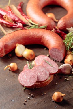 Eski ahşap bir masada salamlı sandviç..