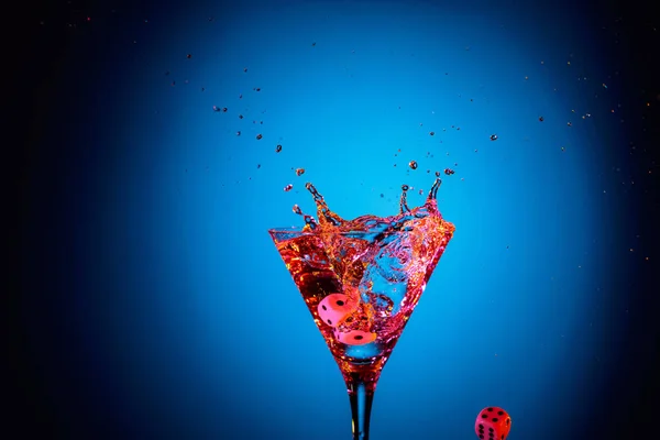 Los dados caen en un vaso de martini. Cóctel colorido en el ingenio de cristal — Foto de Stock