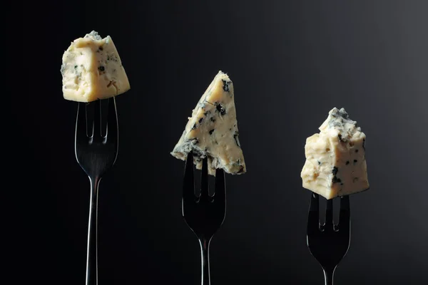 Pieces of blue cheese on a forks.