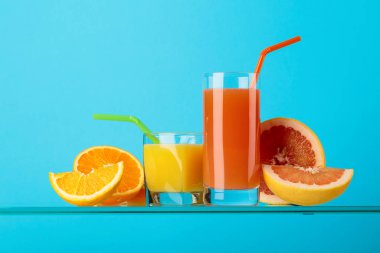 Bir bardak greyfurt ve taze meyveli portakal suyu.