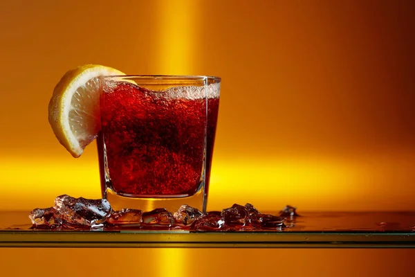 Cocktail met cola, citroenschijfje en ijsstukjes. — Stockfoto